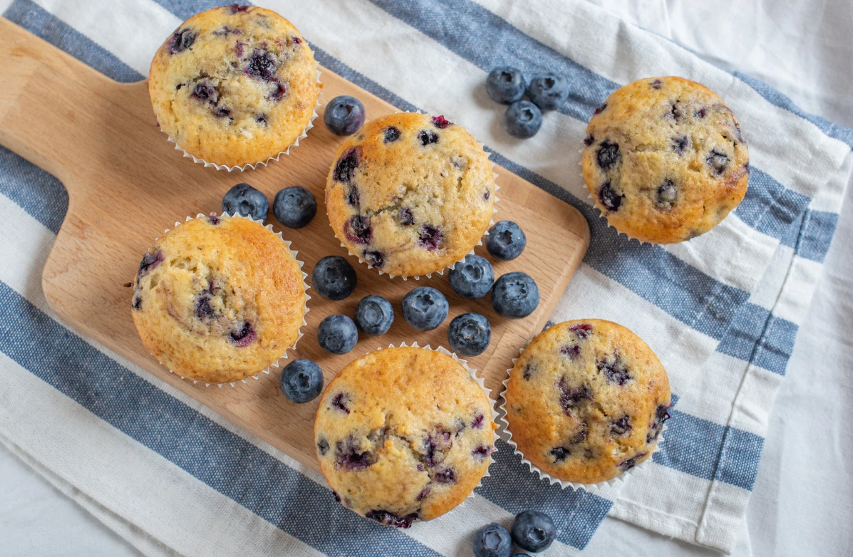 Des muffins dorés surmontés de myrtilles juteuses sortant tout juste du four.