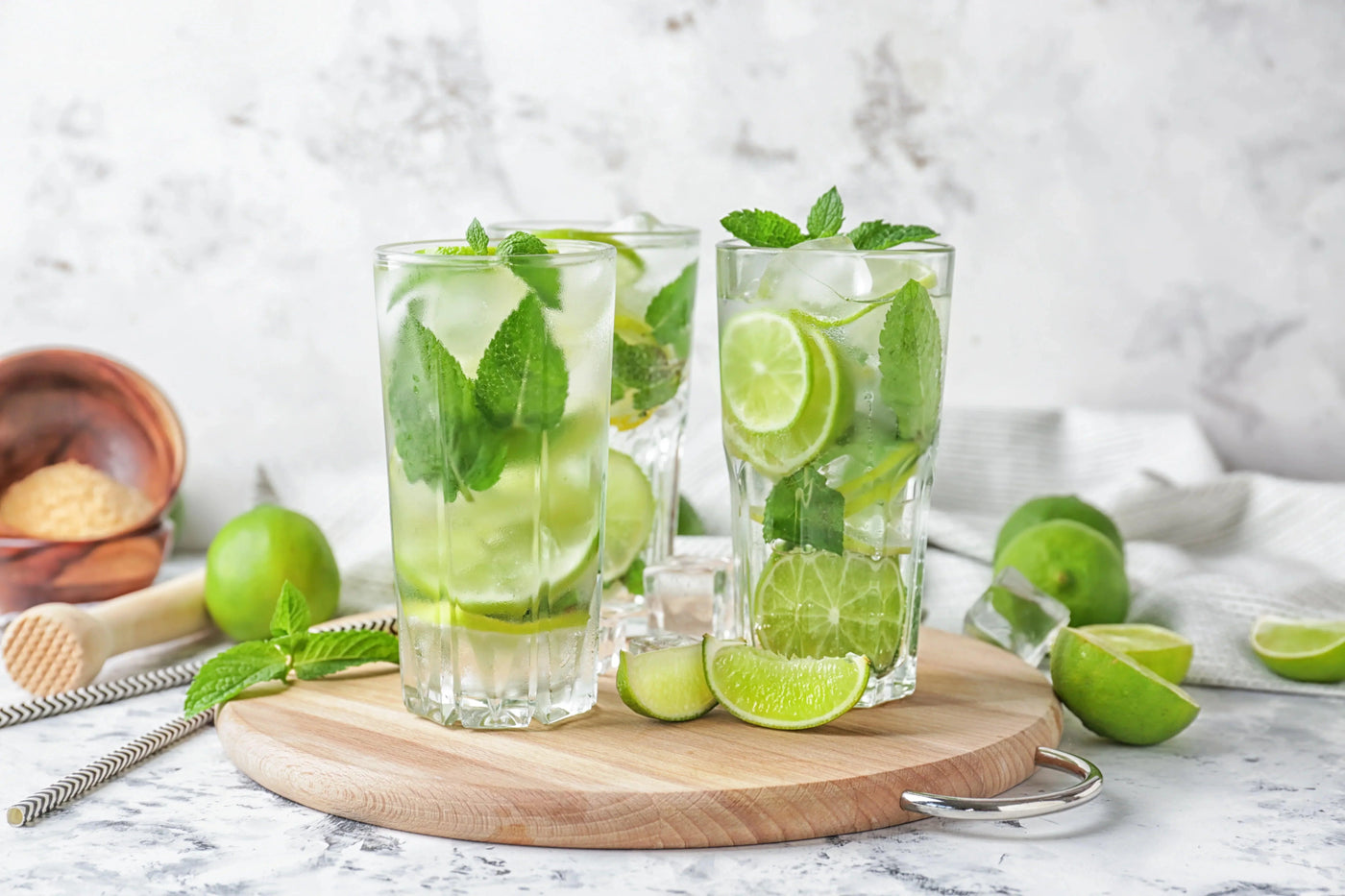 Verre de Mojito sans alcool garni de menthe fraîche, de tranches de citron vert et de glace pilée.